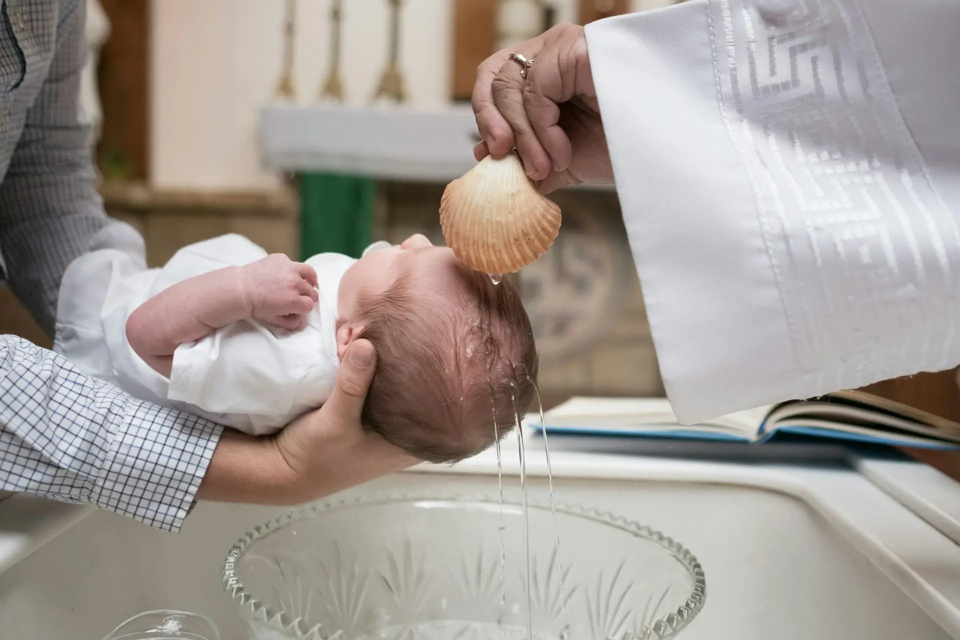 Ein Baby, das von einem Priester getauft wird.